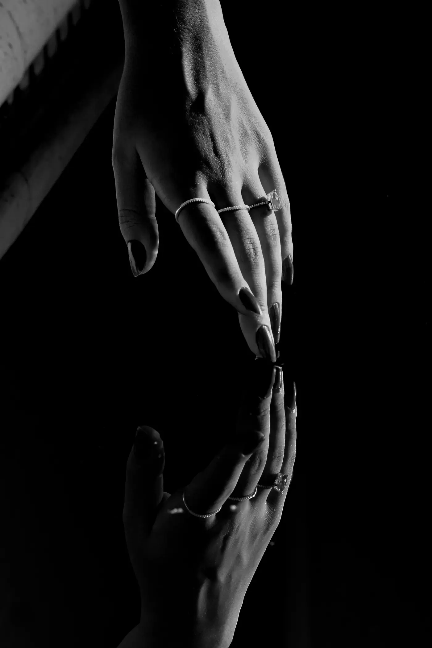 Deux mains qui se frôlent, en noir et blanc